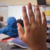 Young student raises hand in classroom