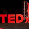 3D, red TEDx logo on stage, photo courtesy of TEDx Oakland University