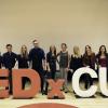 Committee executives pose for a photo in front of the TEDxCU letters