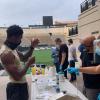 CU Boulder athlete holds up a vial for testing his saliva for the coronavirus.