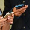 Two people text on their smartphones
