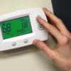 Person adjusts temperature on thermostat