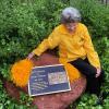 Peggy Coppom sits next to a plaque honoring her and her late twin sister, Betty Hoover. (Photo by Sarah Adderholt/University of Colorado)