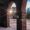 Sun peaks through pillars outside of UMC