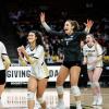 Women's volleyball team celebrates on the court