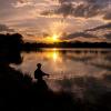 Person fishing on a lake at sunset