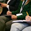 Attendees listen in and take notes during a speaker session