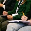 Attendees listen in and take notes during a speaker session