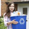 person holding a recycling bin full of items