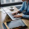 person writing on laptop