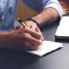 Person writing in a notepad