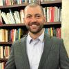 Zachary Owens in front of bookcases