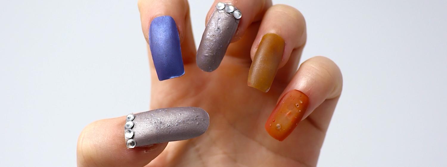 Photo of a hand with fingernails in different colors