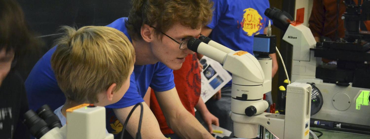 Assistants demonstrate microscopes