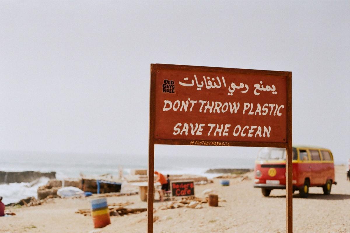 A photo of a sign at the beach that reads Don't Throw Plastic, Save the Ocean