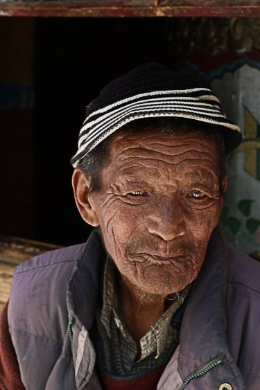 A photo of an elderly Indian man wearing a black knitted hat