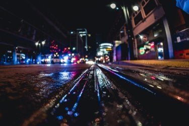 A photo of a wet street reflecting lights at night