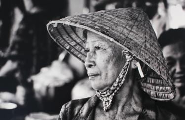 A black-and-white photo of a woman in a straw hat