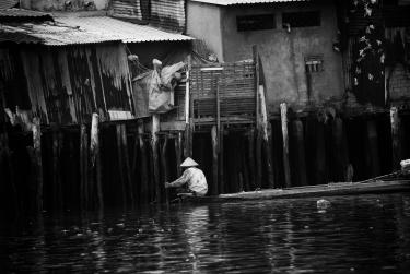 A black-and-white photo of a man in a river