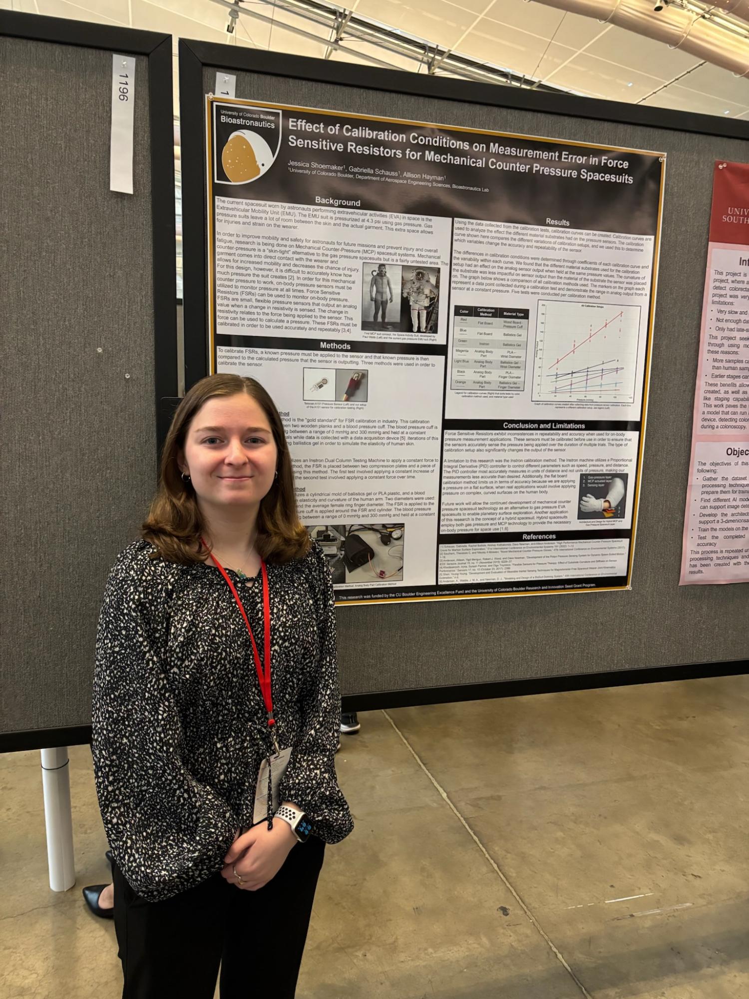 Student posing with their research poster