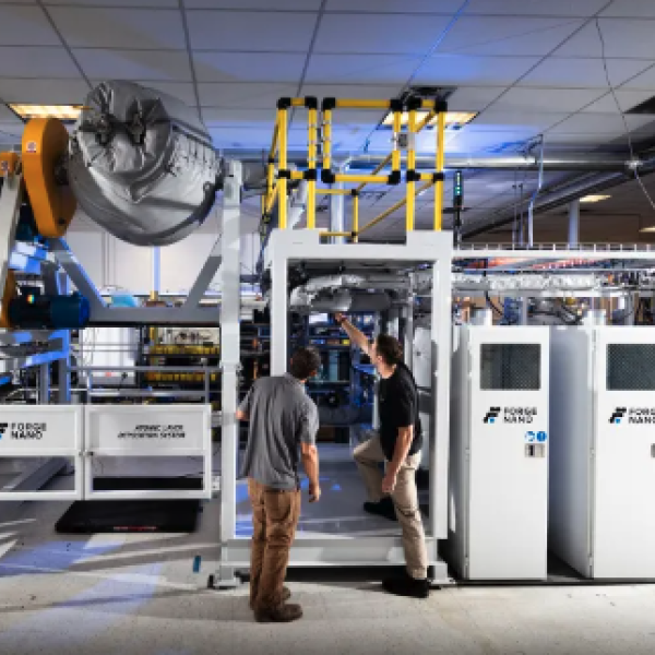 Two men work on a large space full of mechanical machinery