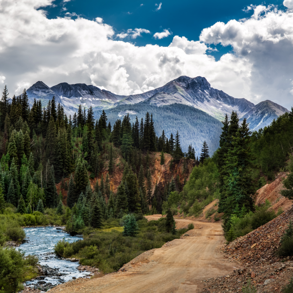 Rock mountains overlooking a dirt road and creek