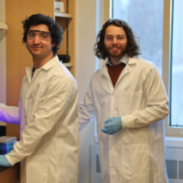 Two men in lab lab coats work in a laboratory