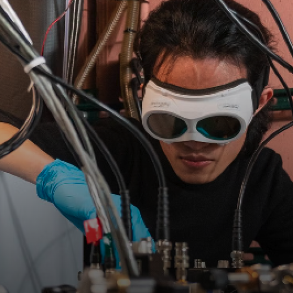 An engineer wearing advanced goggles works on a machine