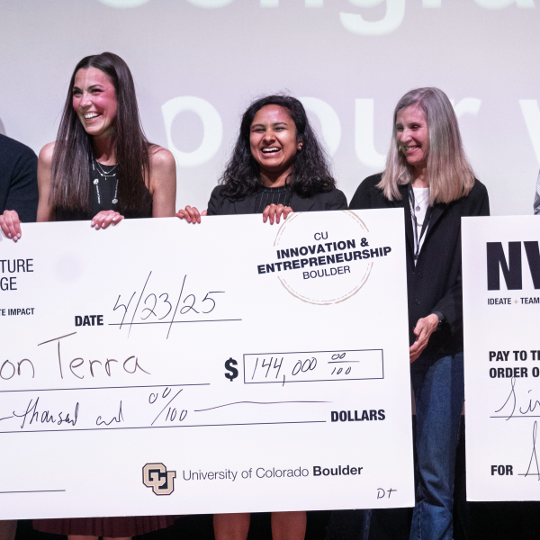 A group of people pose together with a giant prize check