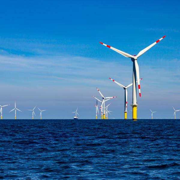 Nothin but ocean as far as the eye can see, and windmills reach high from the water toward a blue sky