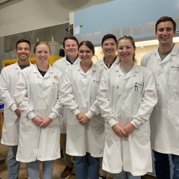 A group of people in lab coats pose for a picture