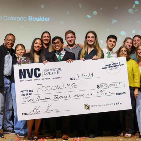 Team stands with giant prize check