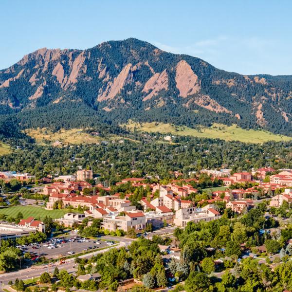 Aerial photo of the CU Boulder campus with the Boulder Flatirons in the background.