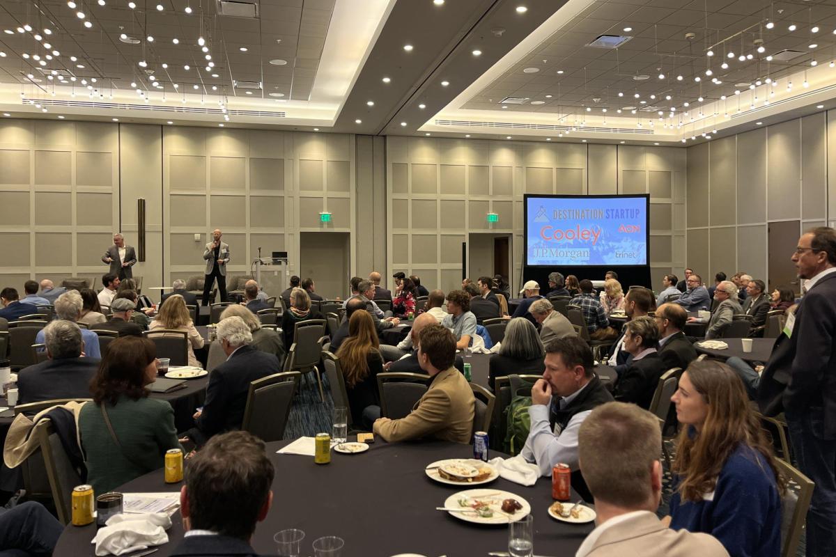 A ballroom full of people watching a presentation