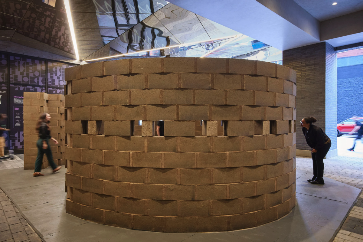 A large circular wall made up of brown cinderblocks.