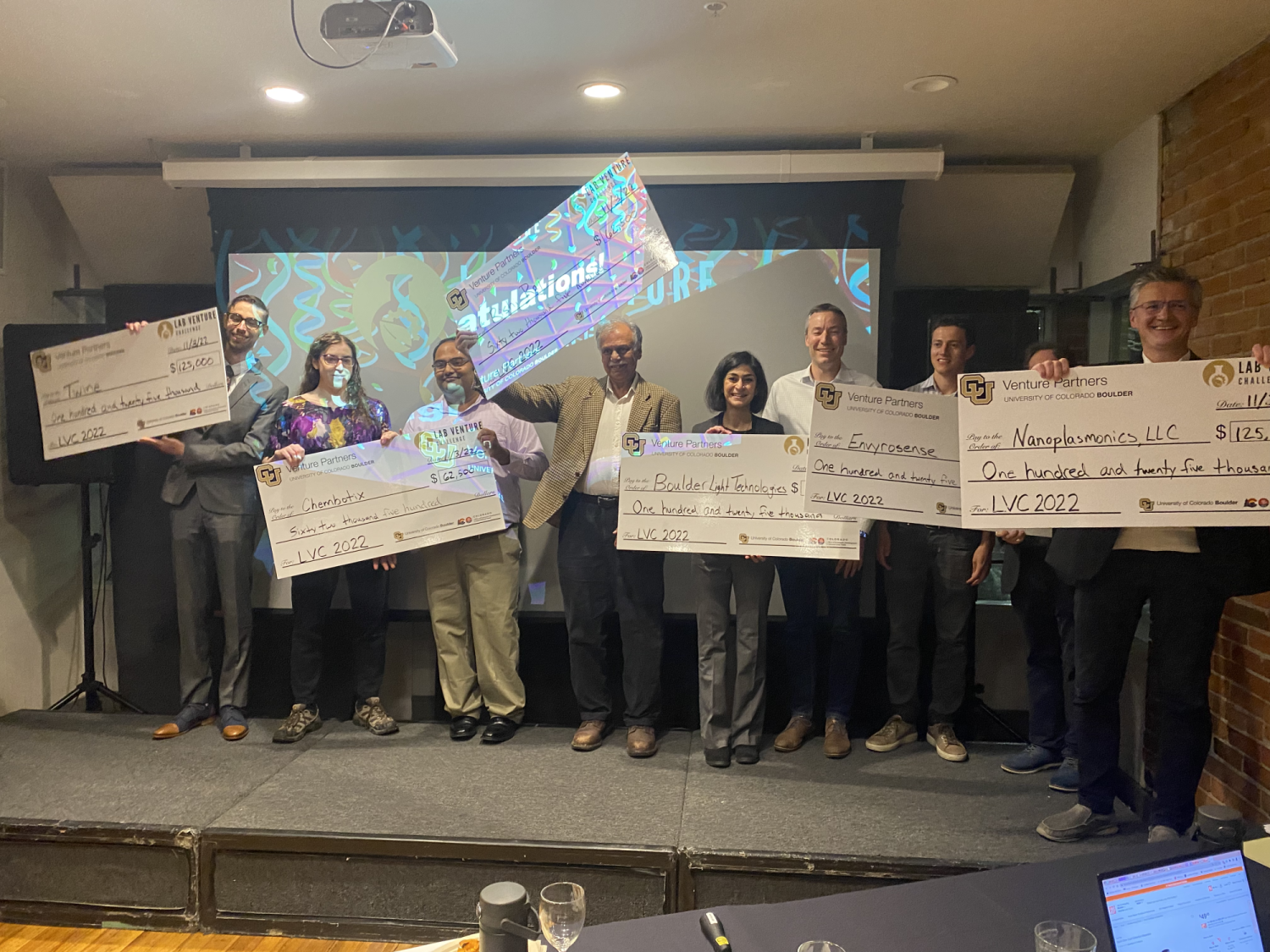 Winners hold up their large prize checks