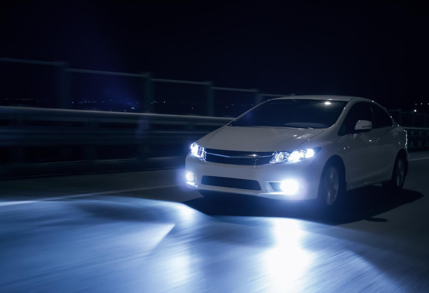 Car driving at night with headlights on