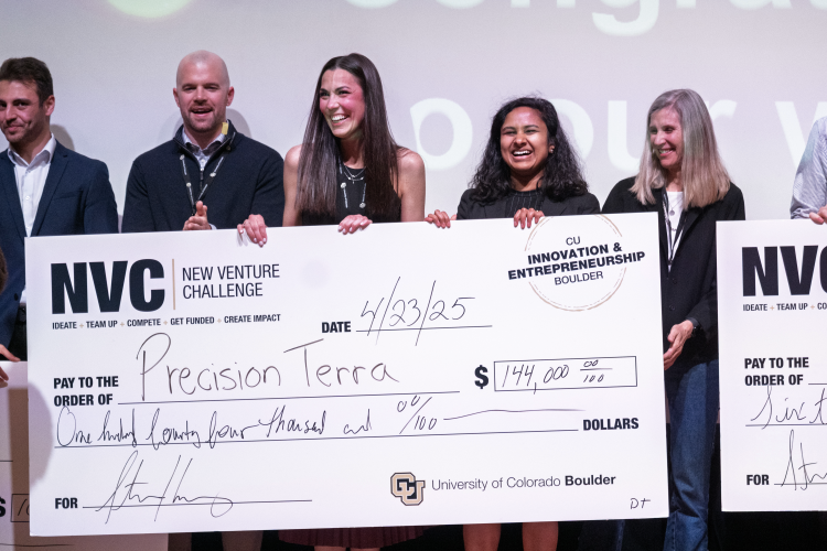 A group of people pose together with a giant prize check
