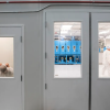 A person puts on a head covering and lab suit before entering a clean room.