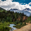 Rock mountains overlooking a dirt road and creek