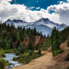Rock mountains overlooking a dirt road and creek