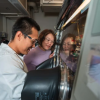 A woman and a man smile as they work together in an engineering lab