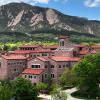 An aerial photo of the iconic CU Boulder campus with the Boulder flatirons in the background