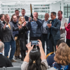 A group of people cut through a ribbon with giant scissors