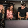 A man and two women work together at a lab work table.