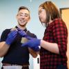 Wil Srubar and student Sarah Williams discuss the block-like materials they are holding in a laboratory.