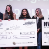 A group of people pose together with a giant prize check