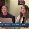 Two young women sit in front of a laptop smiling