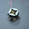 A tiny robot that resembles a chunky spider walks across a table