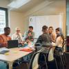 A diverse group of people work together in a brainstorm room